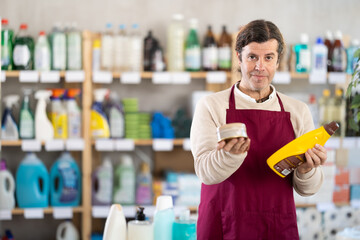 While working in store, European man stand at sales area of household shop, ready to communicate...