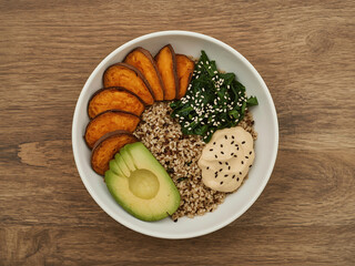 Nutrient-Rich Vegan Meal in White Bowl on Wooden Table – Top View Concept