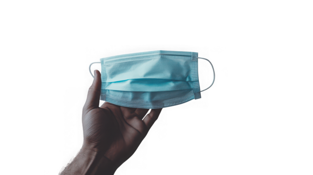 A persons hand holds up a light blue disposable medical face mask offering protection against a transparent background