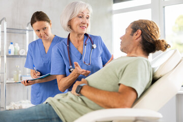 Obraz premium Gastroenterologist doctor consulting man in clinic. Patient having medical exam with doctor on illness from stomach discomfort.