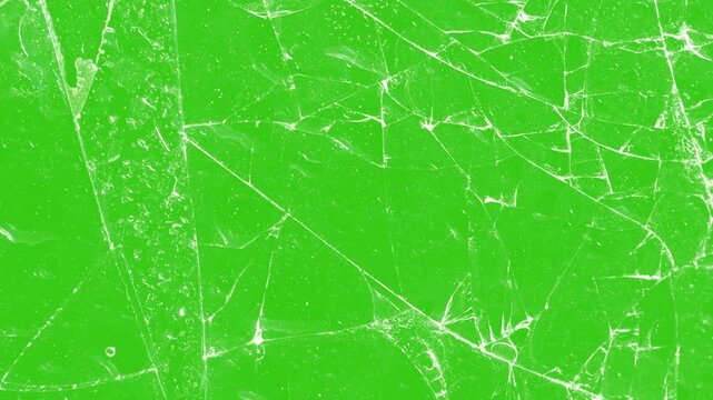 Crack Animation that looks like glass. footage of broken glass, footage of broken glass, with green screen in the background. Super slow motion of shattering glass against green screen background.