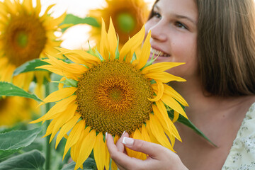 Closeup smiling teenage girl in a field of sunflowers. Enjoying life.
