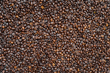Top view of fresh roasted coffee beans. Closeup overhead shot of glossy roasted coffee beans, perfect for backgrounds, cafe branding, packaging, or coffee-related content.