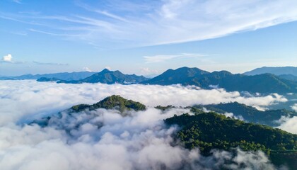 Fototapeta premium Aerial View of Green Mountains Covered in White Fog Under Blue Sky