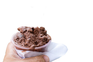 Close-up, male hand with a cardboard cup filled with chocolate ice cream. Transparent background.