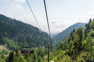 Cabs on the cable car stands against the backdrop of a summer forest and mountain peaks, Rosa Khutor. Sochi, Russia - 10 June 2025