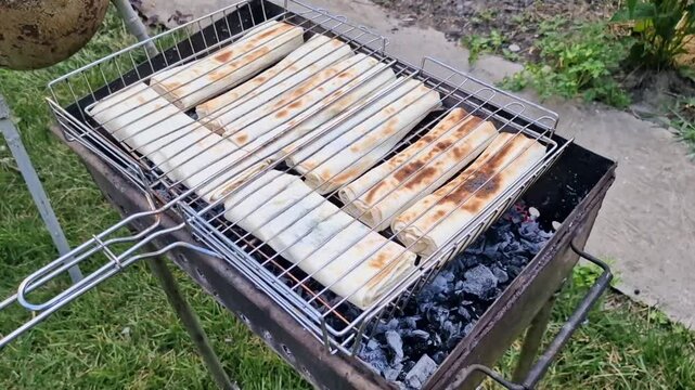 Lavash with filling are fried on the grill. Barbecue