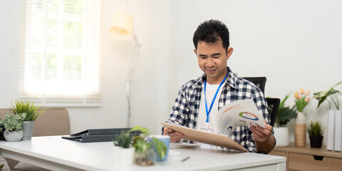 Student studying. Young man reading documents in bright office.