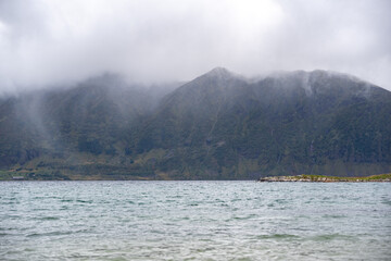 Dramatic Nordic Fjord Landscape: Misty Mountains & Serene Waters Under Overcast Sky – Ideal for...