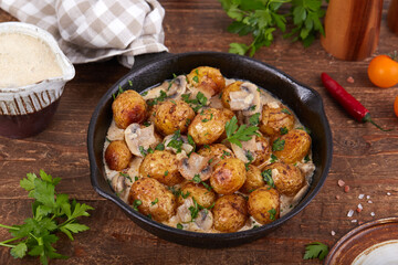 Baby potatoes. Roasted potatoes served with mushrooms, onion and cream sauce. Side dish.