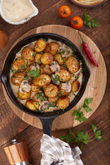 Baby potatoes. Roasted potatoes served with mushrooms, onion and cream sauce. Side dish. Top view.