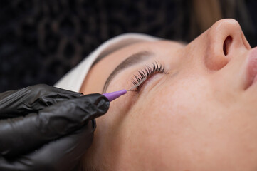 The process of professional eyelash lamination in a salon. 