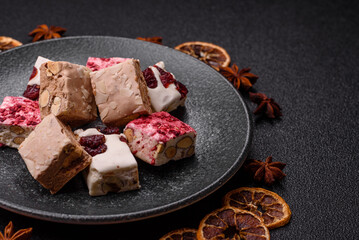 Nougat or white caramel with hazelnuts and pistachios and strawberry pieces. Nougat with nuts