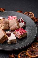 Nougat or white caramel with hazelnuts and pistachios and strawberry pieces. Nougat with nuts