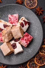 Nougat or white caramel with hazelnuts and pistachios and strawberry pieces. Nougat with nuts