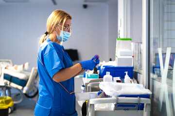 Nurse preparing medical equipment on a cart in hospital room