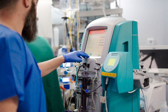 Doctor operating medical equipment in hospital room