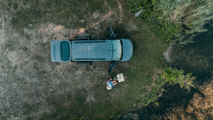 Aerial view of mini campervan wild camping by a lake in Bavaria surrounded by nature travel freedom...