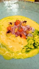 Exotic gourmet dish featuring edible iça ants, seafood, and colorful spheres on a creamy yellow puree with green sauce, served in a rustic artisanal ceramic bowl. A fine dining, avant-garde meal.