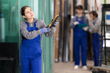 During work process, girl employee sends signal from control panel to lifting machine, moving heavy...