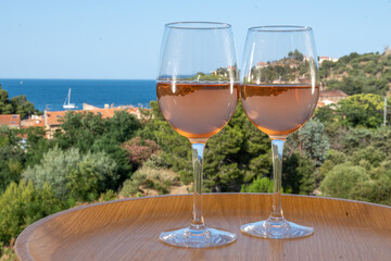 Summer vacation on Mediterranean sea, drinking cold rose wine in glass in sunlights, Collioure, Occitanie, South of France, tourists destination