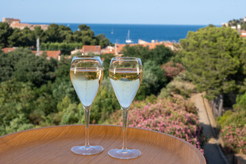 Summer vacation on Mediterranean sea, drinking cold sparkling champagne, cava wine in glass in sunlights, Collioure, Occitanie, South of France, tourists destination