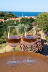 Summer vacation on Mediterranean sea, drinking cold rose wine in glass in sunlights, Collioure, Occitanie, South of France, tourists destination
