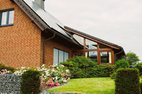 This charming brick house boasts an array of modern features and is beautifully surrounded by a lush garden full of vibrant flowers, providing a picturesque scenic landscape that enhances its appeal