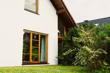 This contemporary house features a stunning exterior design, enhanced by lush greenery and large...