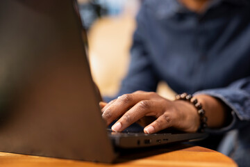 African american woman multitasking on a laptop in her stylish loft, fully connected to the internet while managing her freelance tasks and remote responsibilities. Browsing web at her home.