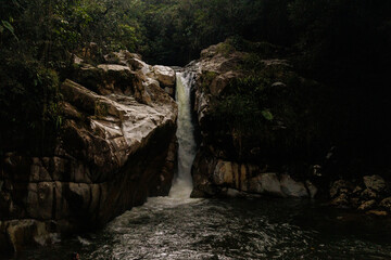 Impresionante cascada del Río Guatapé cayendo con fuerza en una poza natural, enmarcada por rocas...