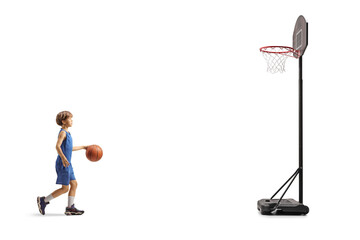 Full length profile of a boy leading a basketball