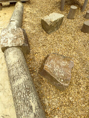 Natural Play Area Featuring Textured Logs and Geometric Rocks on a Bed of Wood Chips for Outdoor Activities