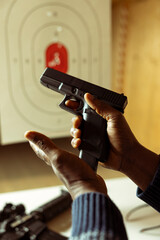 Close up of person hands methodically inserting magazine into handgun, preparing to chamber round...