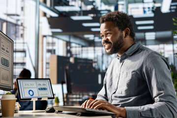 Black business manager engaged in budget analysis and strategy development at workstation,...