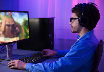 Online Gaming. Gamer Guy Playing Games Sitting At Desktop PC At Home At Night. Selective Focus, Low...