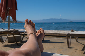 Relaxing by the beach with sun-soaked feet enjoying the ocean view in a tranquil coastal setting