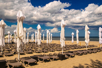 Sunny summer beach on the Baltic Sea in Sopot. Lounge chairs and parasols