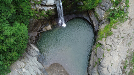 Aerial View of Hidden Waterfall and Natural Pool in a Rocky Forest Landscape