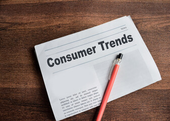 Consumer trends text in headline isolated on wooden table. Newspaper concept