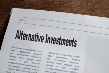 Alternative Invesments text in headline isolated on wooden table. Newspaper concept