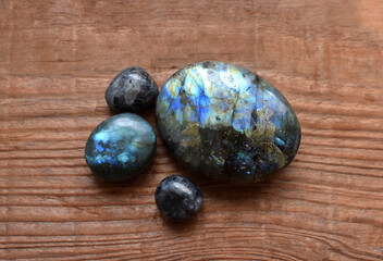 Beautiful natural labradorites with iridescence  on a wooden  background. Healing crystals, semi-precious stones
