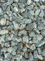 This closeup view offers a detailed look at dark gravel that has a dusty surface, making it ideal for various construction projects as well as landscaping purposes, enhancing infrastructure layout