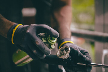 A worker sprays a product onto a tool.