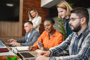 Group of People Sitting at a Table With Laptops