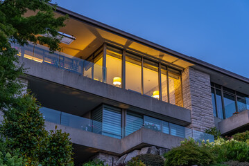 Two story stucco luxury house with nice Spring blossom landscape at night in Vancouver, Canada, North America. May 2025.