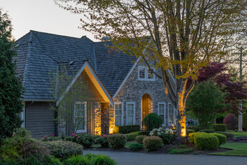 Two story stucco luxury house with nice Spring blossom landscape at night in Vancouver, Canada, North America. May 2025.