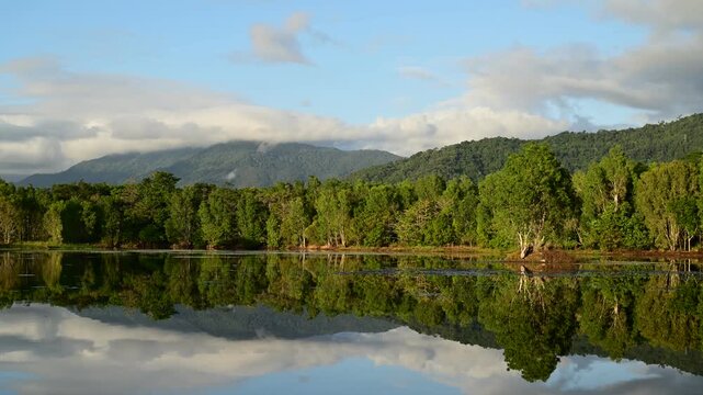 Early morning timelapse at Lake Jabiru in the Cattana Wetlands, north of Cairns, Queensland, with mist rising over still water and the Macalister Range forming a tranquil backdrop.