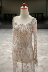 Close-up of a handcrafted wedding dress bodice. Features intricate silver beadwork, sequins, and a...