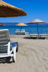 Empty beach with straw umbrellas and loungers